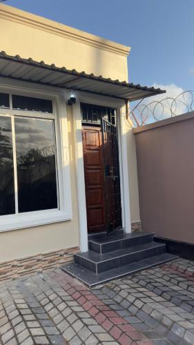 a front door of a house with a window at Grace Haven Airport Day-Use & Overnight Stays Hotel in Dar es Salaam