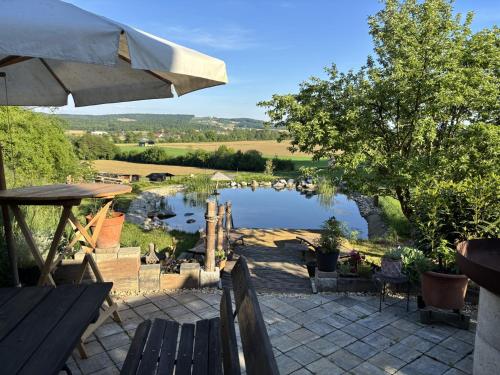 a view of a lake from a patio with an umbrella at Exklusives Zimmer im Kräuterstöckl mit Frühstück gegen Aufpreis in Muggendorf