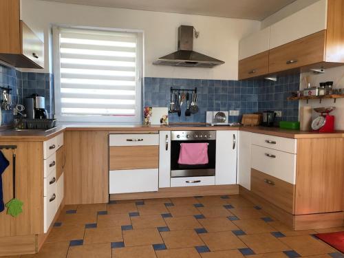 a kitchen with wooden cabinets and a white oven at Urlaubsort Fränkisches Seenland in Haundorf