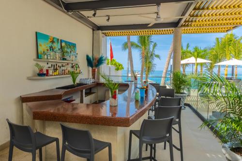 a bar in a restaurant with a view of the ocean at Copacabana Beach Hotel Acapulco in Acapulco
