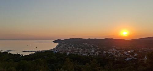 a view of a city with the sunset in the background at Hideaway Thassos in Limenaria