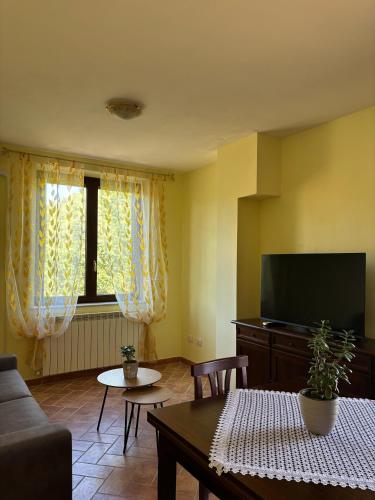a living room with a couch and a television at Casale dei Gelsomini - Country House in Poggio