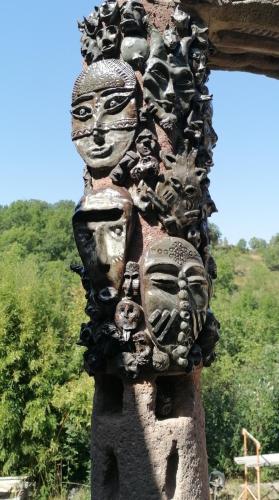 a statue of heads on the side of a building at Le Valadin in Valady