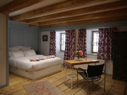 a bedroom with a bed and a table and chairs at Chateau de Marnand in Granges-près-Marnand