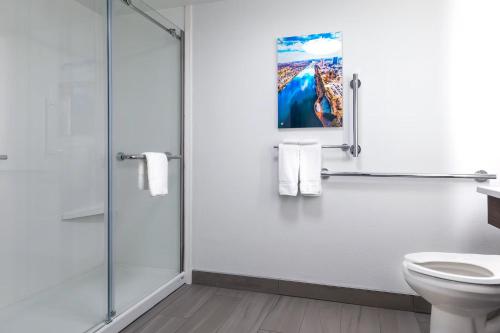 a bathroom with a toilet and a glass shower at Wingate Augusta Washington Road by Wyndham in Augusta