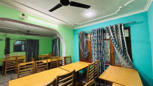 an empty classroom with wooden tables and chairs at Hotel Indra in Srinagar
