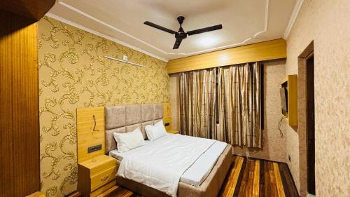 a bedroom with a bed and a ceiling fan at Hotel Indra in Srinagar