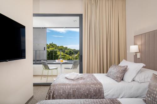 a hotel room with a bed and a balcony at Akademis - Fit Split in Split