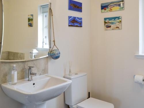 a white bathroom with a sink and a toilet at Eilean View Island View in Midtown Brae