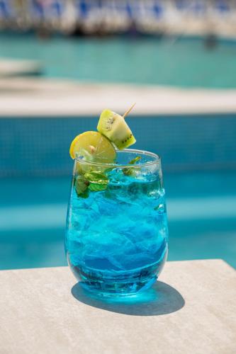 a glass of blue drink with a kiwi in it at Copacabana Beach Hotel Acapulco in Acapulco