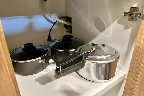 two pots and pans sitting on a shelf at Loft exclusive a 200 metros da Ufu in Uberlândia