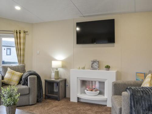 a living room with a fireplace and a tv on the wall at Rosie's Retreat - Uk46724 in Bridlington