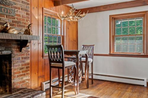 a dining room with a table and chairs and a fireplace at New Pristine Suburban Escape in Newtown Square