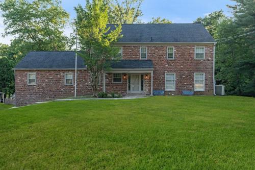 a large brick house with a grass yard at New Pristine Suburban Escape in Newtown Square