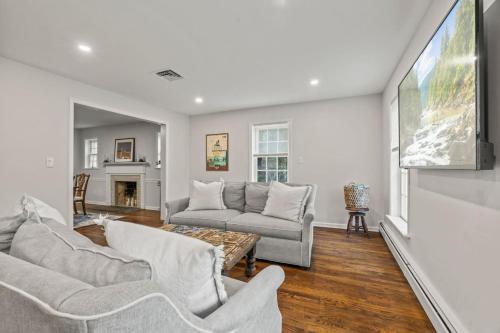 a living room with two couches and a flat screen tv at New Pristine Suburban Escape in Newtown Square