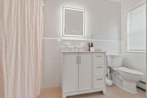 a white bathroom with a sink and a toilet at New Pristine Suburban Escape in Newtown Square