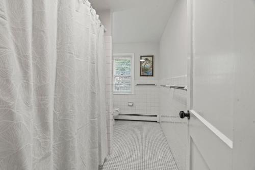 a bathroom with a white shower curtain and a toilet at New Pristine Suburban Escape in Newtown Square