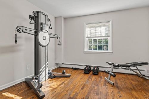 an empty room with a gym with a bench and weights at New Pristine Suburban Escape in Newtown Square