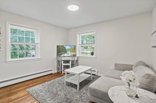 a living room with a couch and a table at New Pristine Suburban Escape in Newtown Square