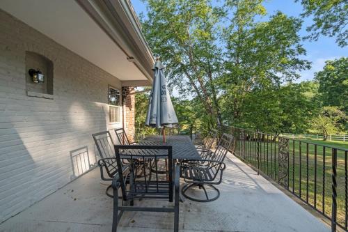 a table and chairs with an umbrella on a porch at New Pristine Suburban Escape in Newtown Square
