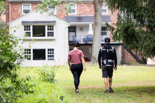 two people walking in front of a house at New Pristine Suburban Escape in Newtown Square
