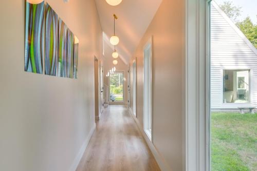 a hallway of a home with wood floors and windows at Custom-Built Home Near Piscataqua River! in Eliot