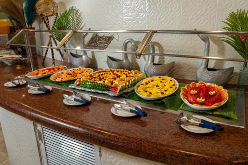 a buffet with many different pizzas on a counter at Copacabana Beach Hotel Acapulco in Acapulco
