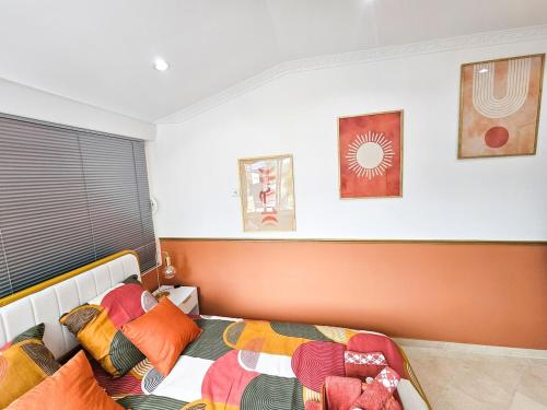 a bedroom with a bed with colorful pillows on it at TerraKota Cosy T2 au cœur d'Evry Courcouronnes in Evry-Courcouronnes