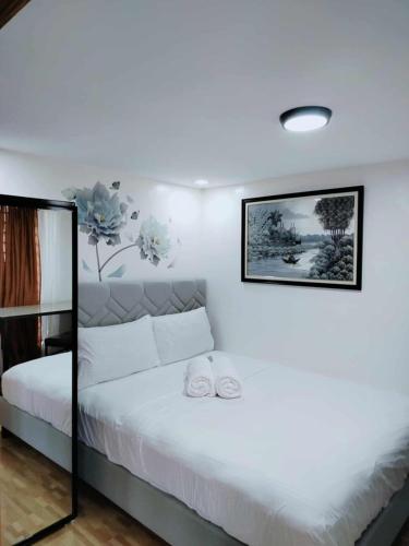 a bedroom with a white bed with two towels on it at 1B - Cabanatuan City's Best Bed and Breakfast Place in Bantug