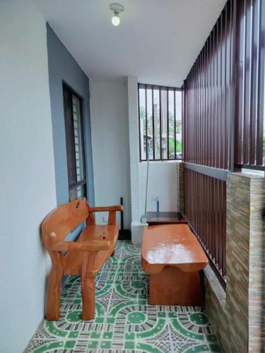 a room with a bench and a table and windows at 1B - Cabanatuan City's Best Bed and Breakfast Place in Bantug