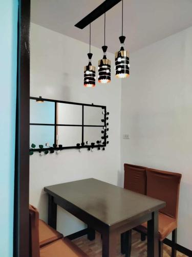 a dining room with a table and two lights at 1B - Cabanatuan City's Best Bed and Breakfast Place in Bantug