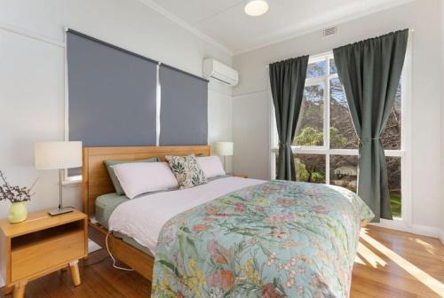 een slaapkamer met een bed en een groot raam bij Cape Cottages - Ollies View in Tanybryn