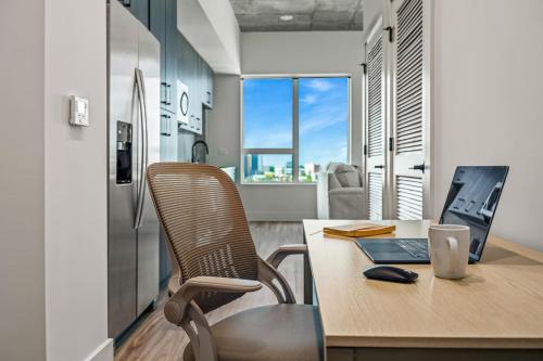 an office with a desk with a laptop and a chair at 14th Floor SkySuite - DT Views! with Pool & Gym in Tampa