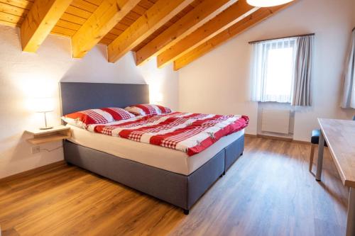 a bedroom with a bed in a room with wooden floors at Edelweiss Pany in Pany