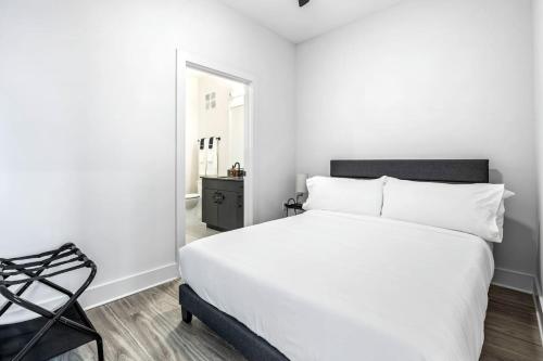 a bedroom with a white bed and a black chair at Modern Channelside 1BD Apartment | Close to DT! in Tampa
