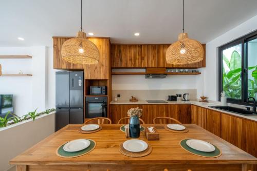 a kitchen with a wooden table with plates on it at Amal Villa #10 by Bali Bliss Properties in Mengwi