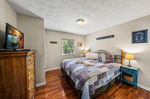 a bedroom with a bed and a dresser and a television at Heaven Sent by American Patriot Getaways in Henderson Springs