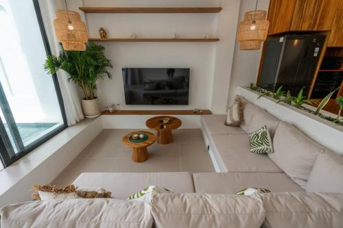 a living room with a white couch and a fireplace at Amal Villa #10 by Bali Bliss Properties in Mengwi