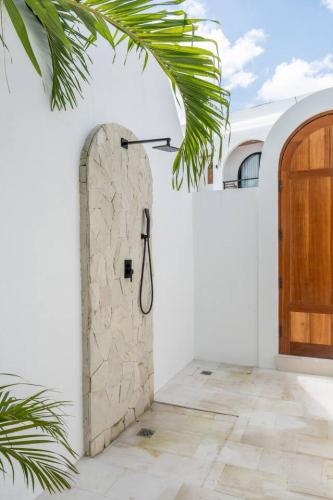 a bathroom with a shower in a white wall at Amal Villa #10 by Bali Bliss Properties in Mengwi