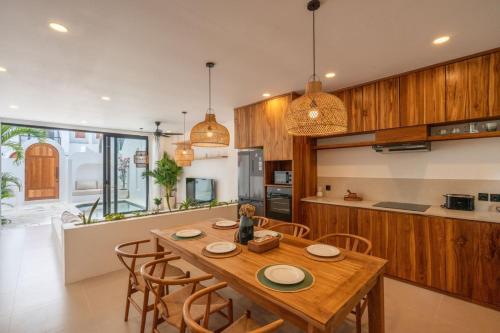 a kitchen and dining room with a wooden table and chairs at Amal Villa #10 by Bali Bliss Properties in Mengwi