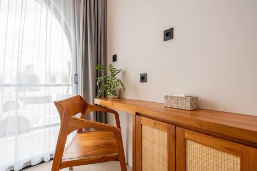 a wooden desk with a chair next to a window at Amal Villa #10 by Bali Bliss Properties in Mengwi