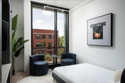 タンパにあるYbor 2BD Haven Free Pool Close to DTのベッドと椅子2脚と窓のある寝室