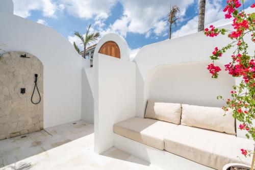 a white room with a white couch and flowers at Amal Villa #10 by Bali Bliss Properties in Mengwi