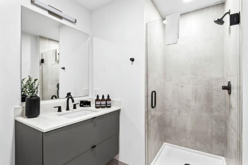 a white bathroom with a shower and a sink at Cozy Downtown Studio Free Pool Close to DT in Tampa