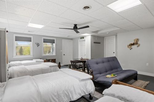 a room with three beds and a blue chair at Central Location 4BR w Boat Slip Option in Gilford