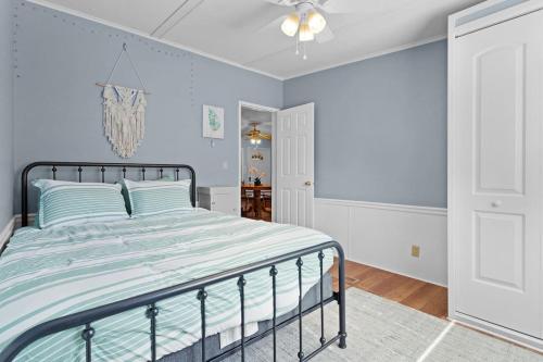 a bedroom with a bed with blue walls and a chandelier at Sunlit 2BR with Lanai on Golf Cart Path in Lady Lake