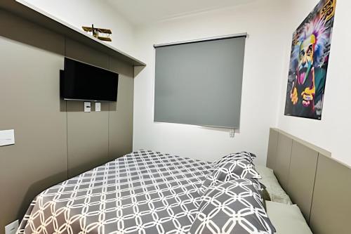 a bedroom with a bed and a flat screen tv at *Loft Refúgio Urbano | Estilo e Conforto. in Uberlândia