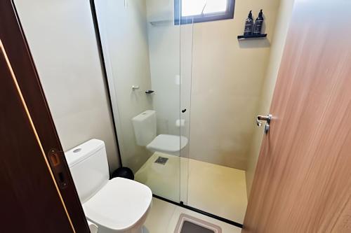 a bathroom with a toilet and a glass shower at *Loft Refúgio Urbano | Estilo e Conforto. in Uberlândia