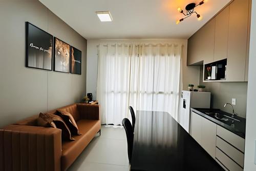 a living room with a brown couch and a kitchen at *Loft Refúgio Urbano | Estilo e Conforto. in Uberlândia