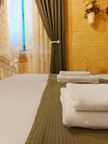 a bedroom with white towels on a bed with a window at Casa Maltija Sliema 4 Bedroom in Sliema